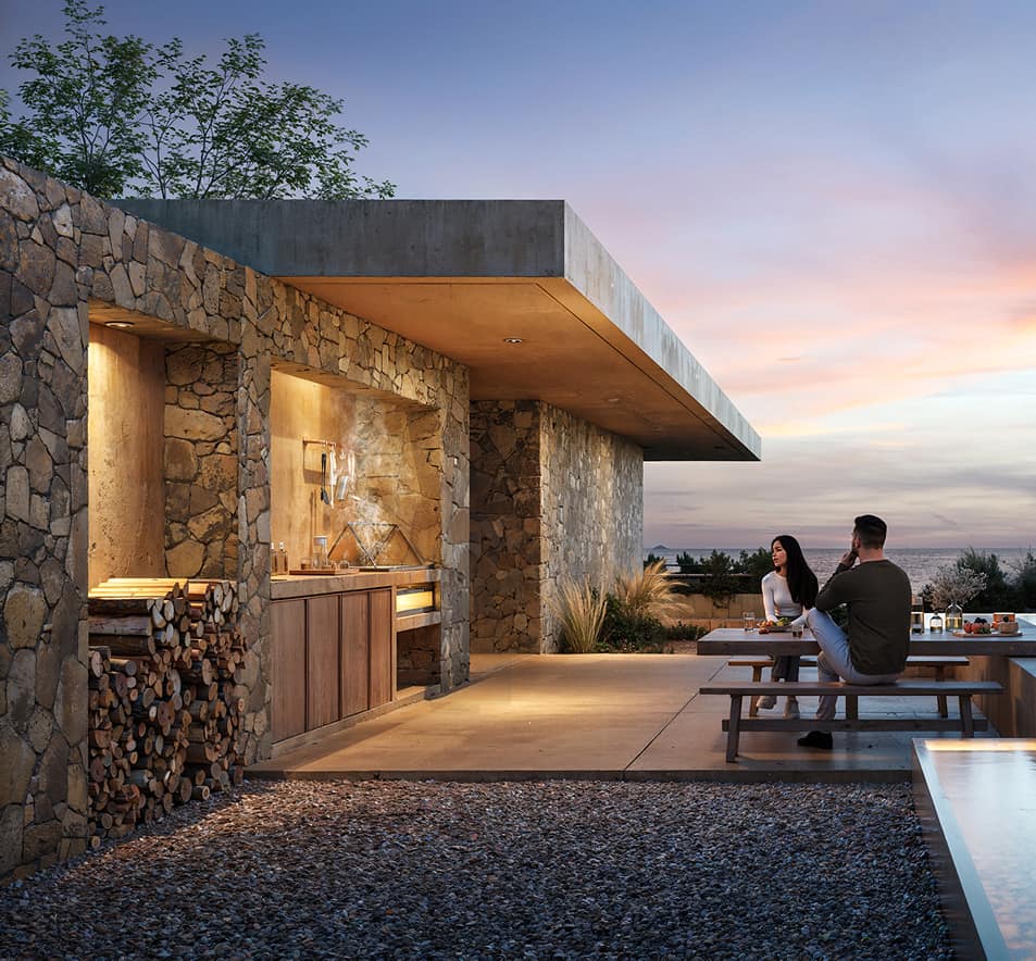 Outdoor stone kitchen and dining terrace at sunset